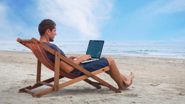 Men learning Spanish online on the beach