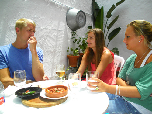 three students of Spanish tasting tapas with school