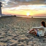 Student sitting on the beach in Denia, Spain