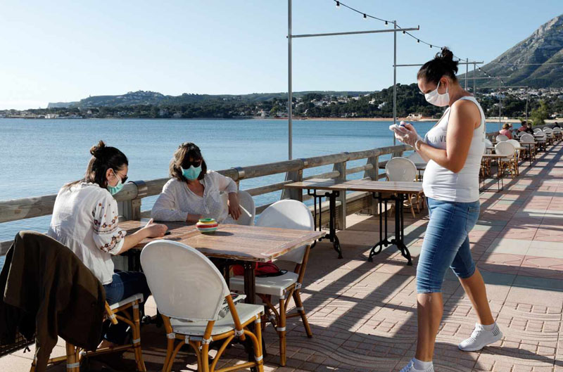 People in a terrace in Denia wearing masks