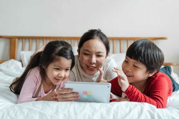 Madre con i suoi due figli che usano un'app per imparare lo spagnolo