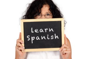 Girl holding a sign of 'learn Spanish'