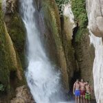 Schulgruppenschüler in einem Wasserfall in Spanien