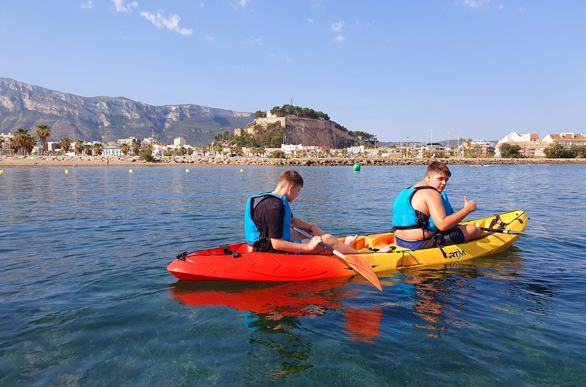 2 teenagers in a kayak with Denia Castle and Montgó in the background