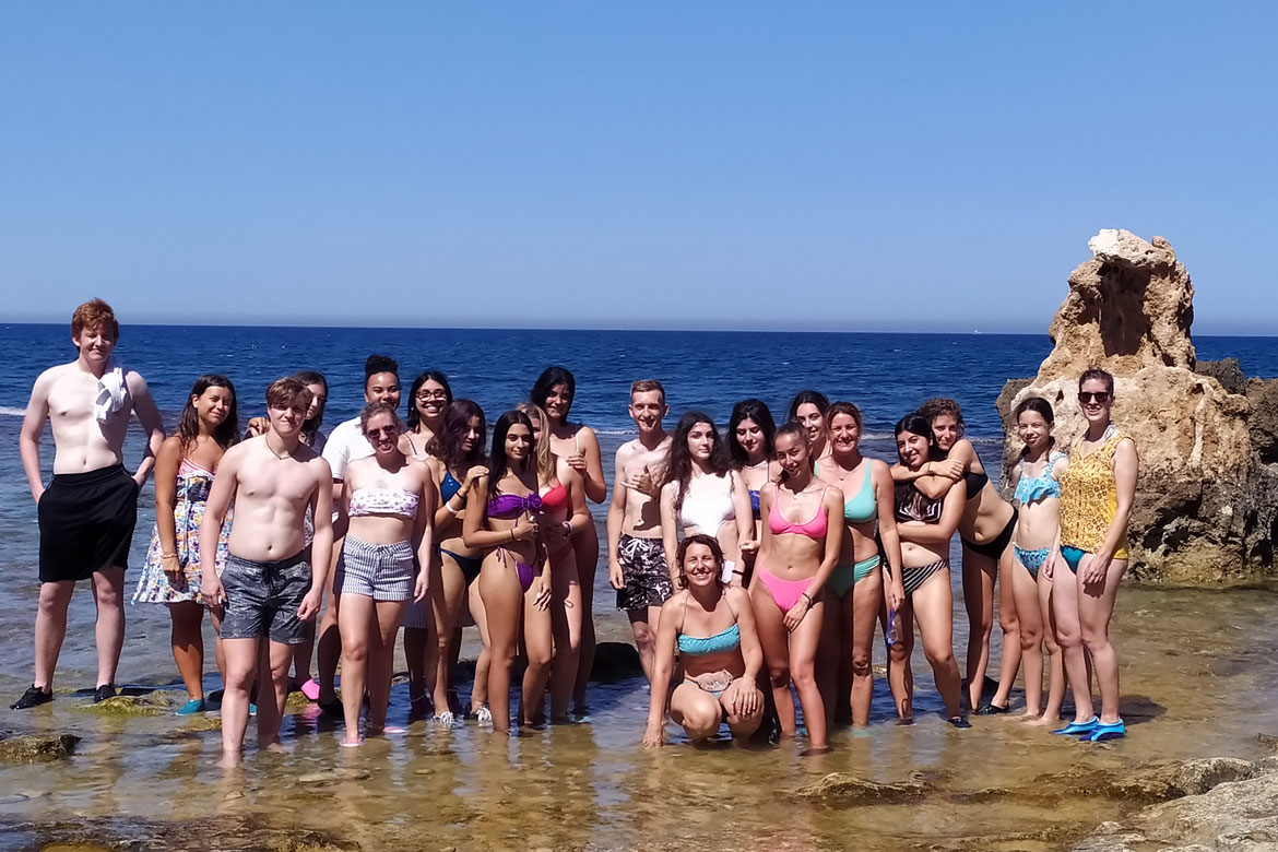 Group of teenagers in a rocky beach in Denia, Spain