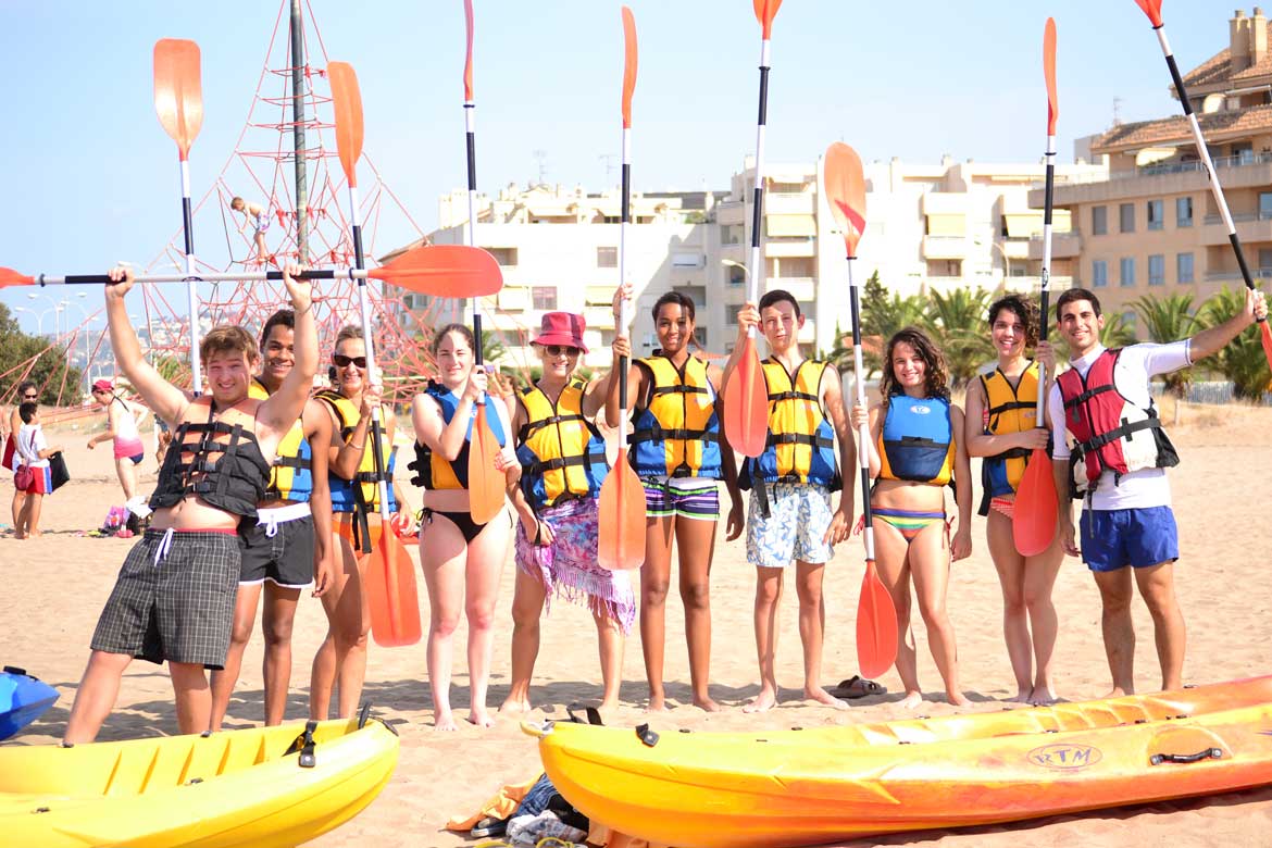 Group of teens with kayaks and holding oars