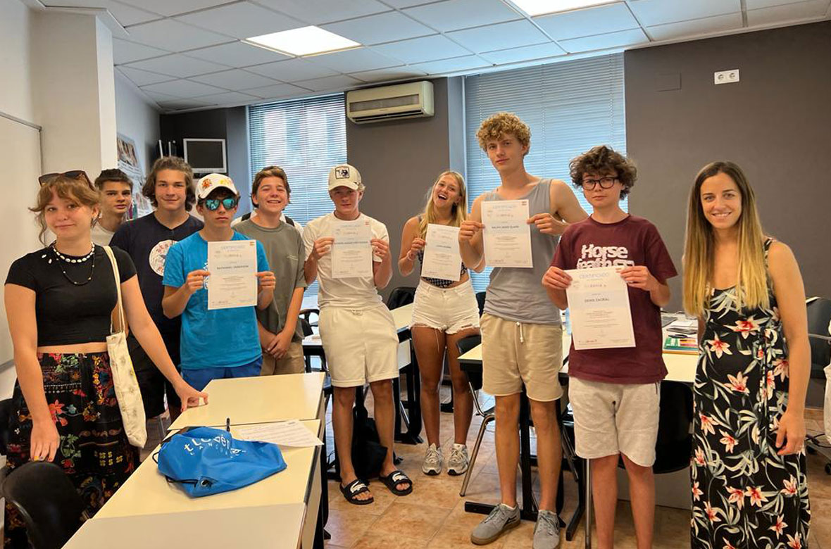Group of teens showing a diploma in their course of Spanish