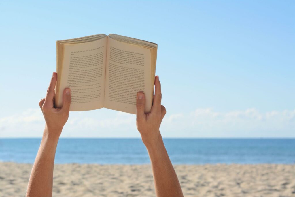 leer tumbado en la arena en la playa de Denia
