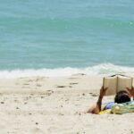 Schüler liest am Strand ein Buch