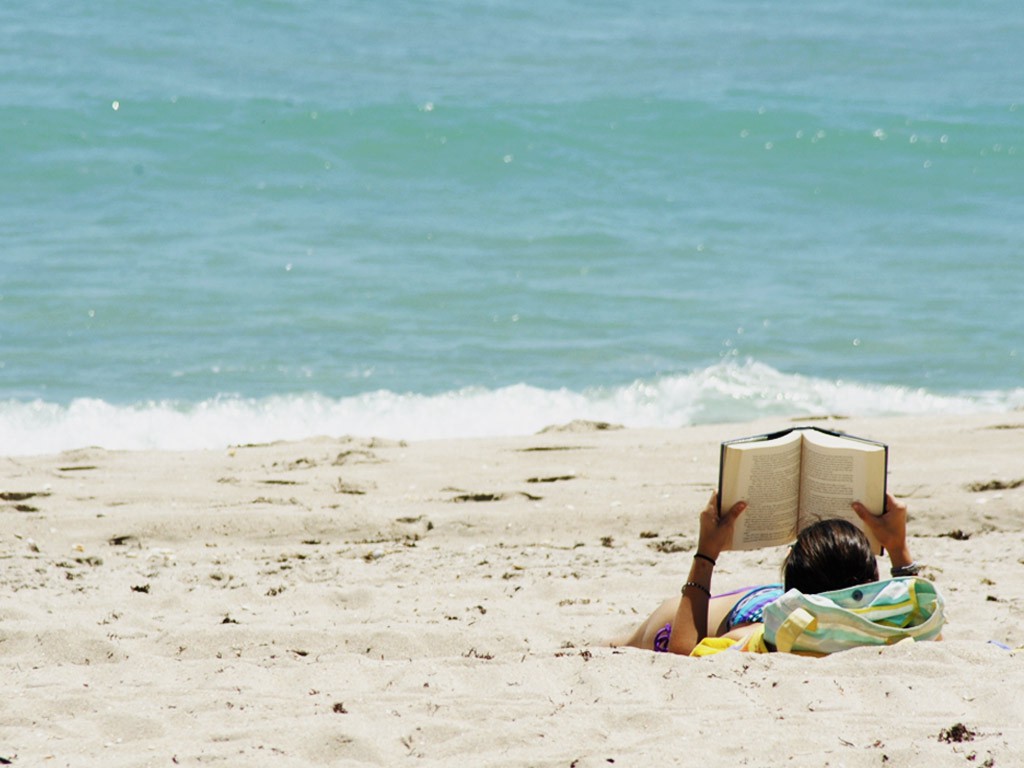 Schüler liest am Strand ein Buch